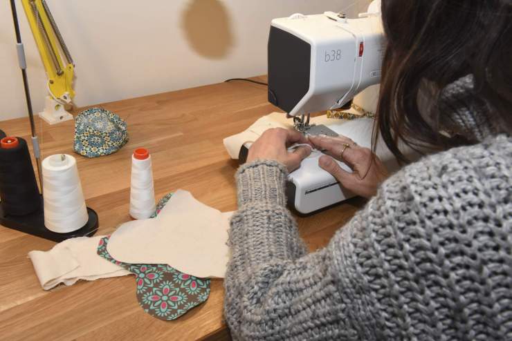 Quelqu'un en train de coudre à la machine à coudre une serviette lavables